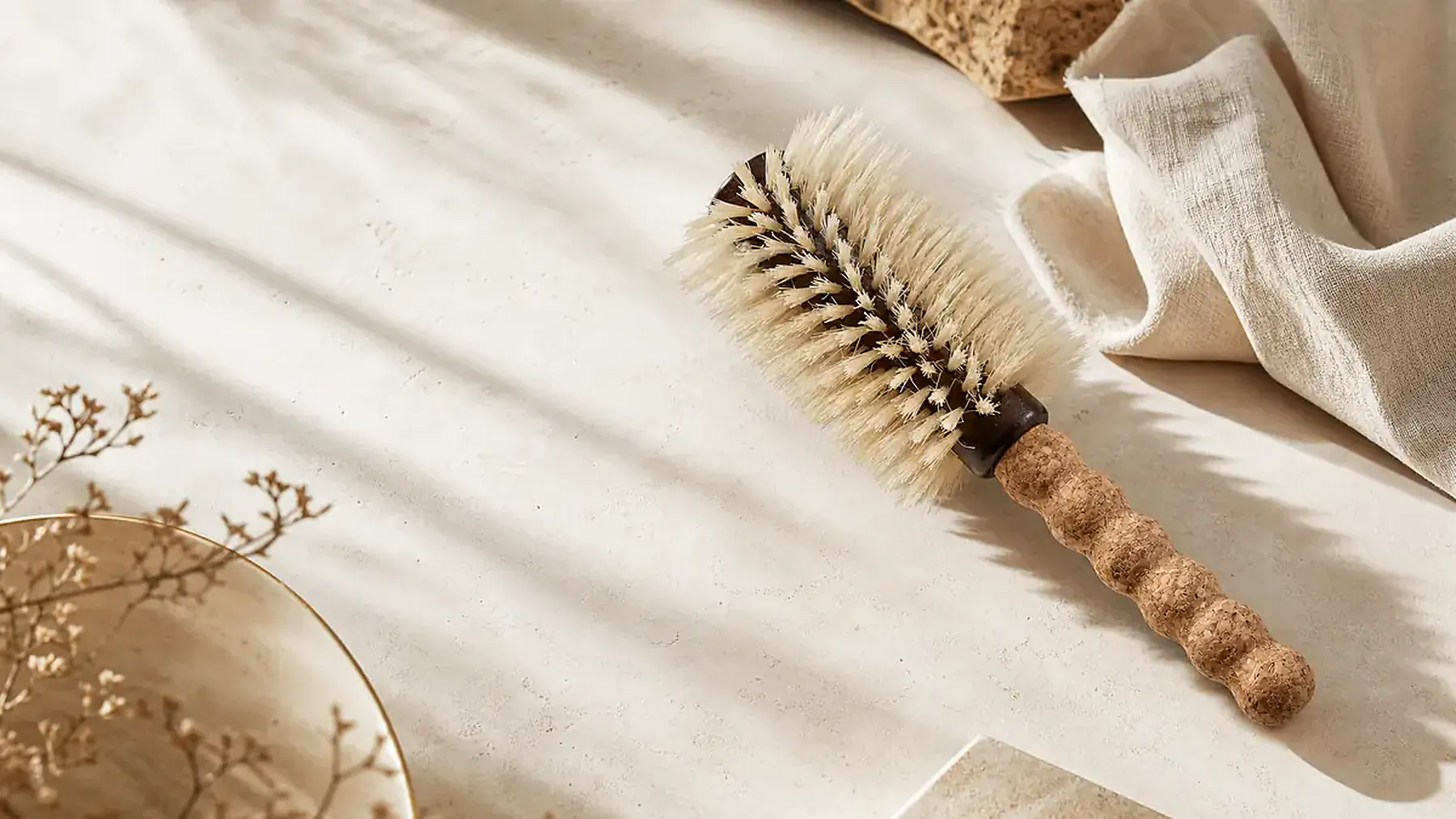TRENFi boar bristle round brush in a warm natural-material editorial scene