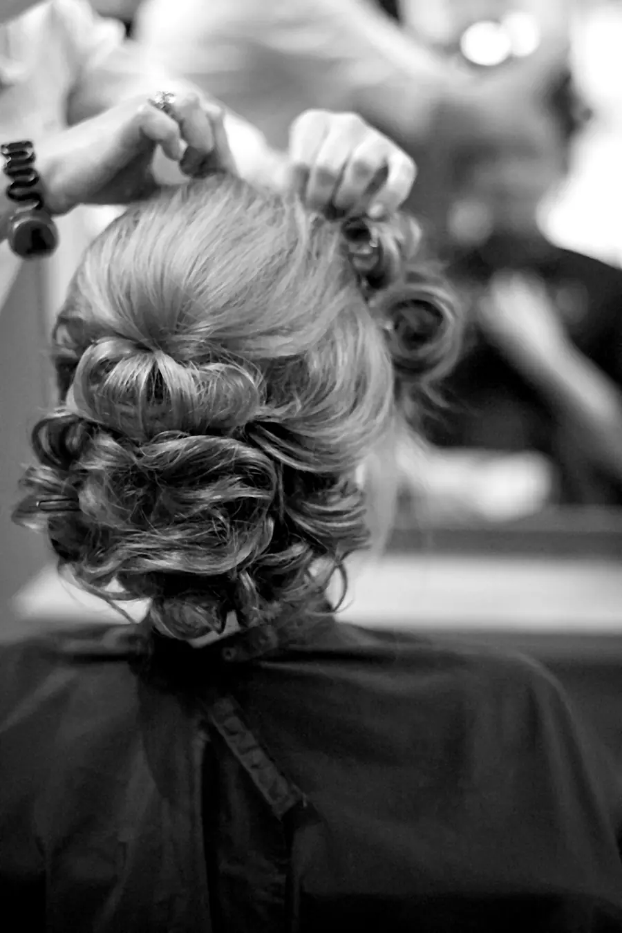 Black-and-white hair stylist shaping a client hairstyle in a salon